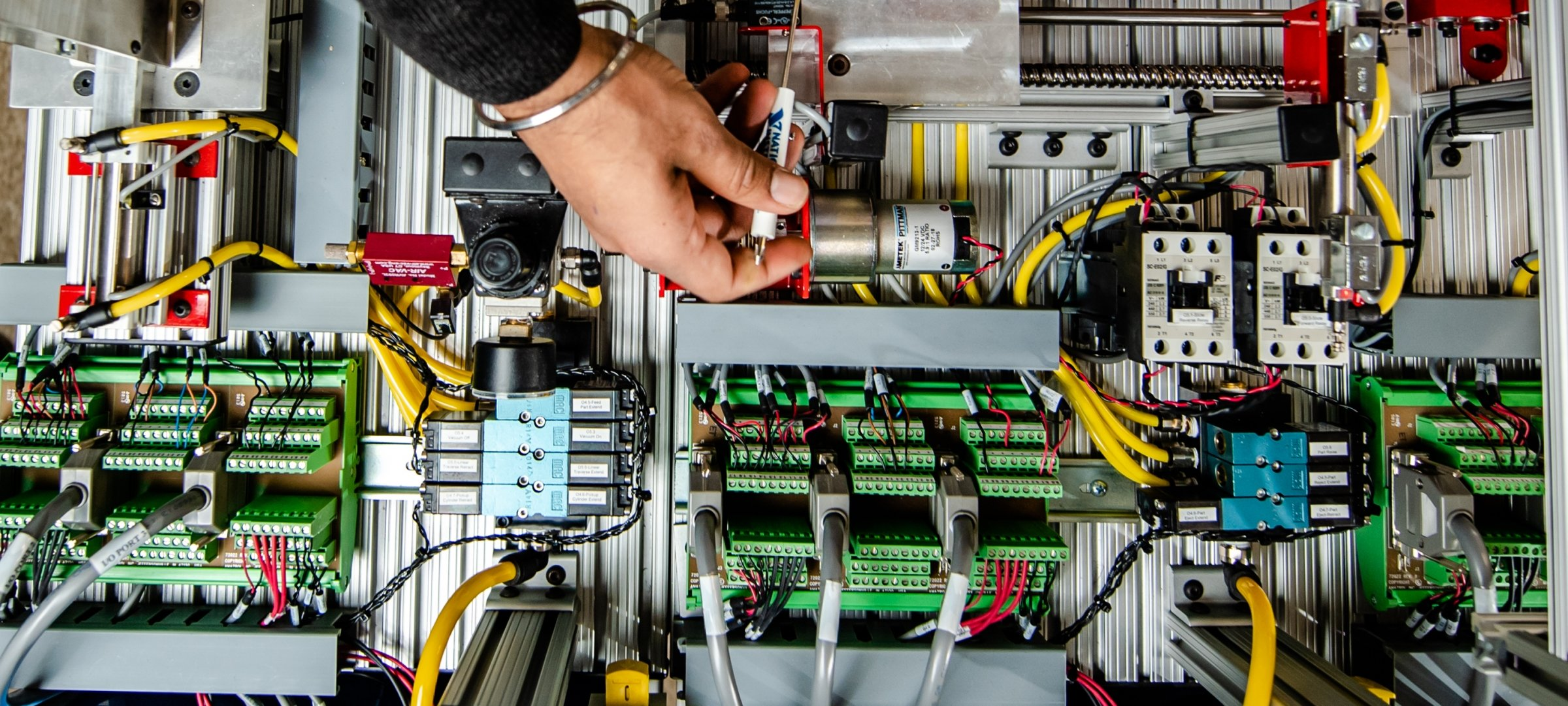 Technician wiring an industrial control panel and terminal blocks
