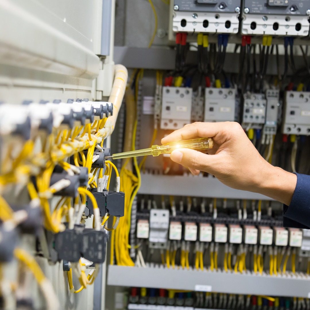 Electrician testing a distribution board with a voltage tester
