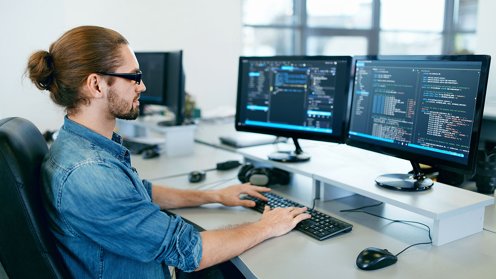 IT technician configuring servers and network infrastructure at a workstation